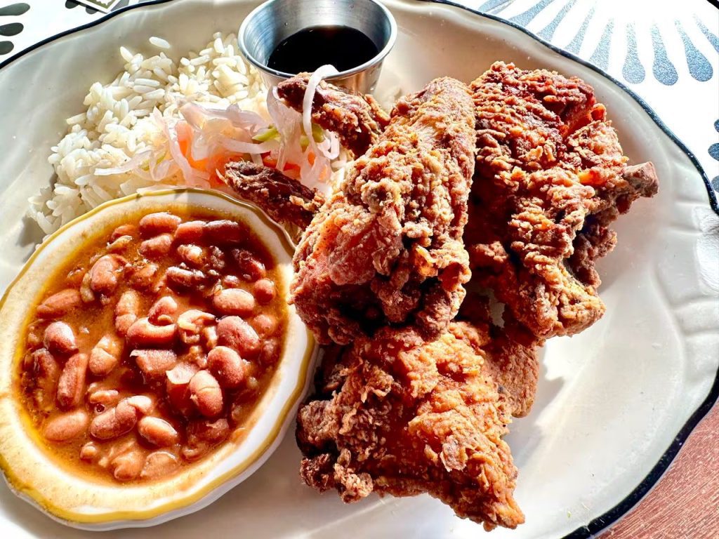 A quarter fried chicken plate with pinto beans, rice, pickled vegetables and a habanero-vinegar dipping sauce at Little Donkey Mexican Restaurant in Homewood, Ala.(Bob Carlton/bcarlton@al.com)